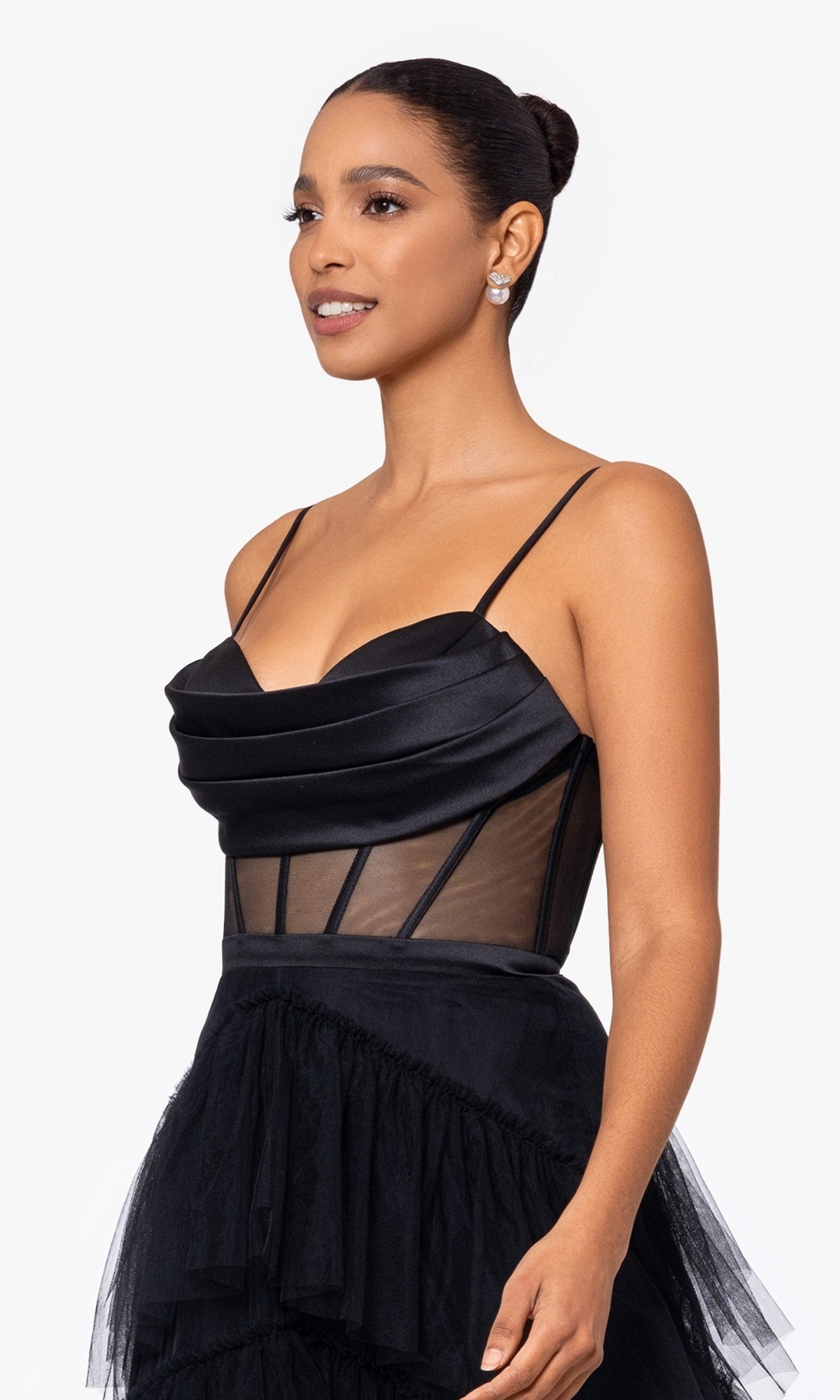 Woman in the Sheer-Waist Long Black Tiered Prom Dress A26249 featuring thin straps, corset waist, structured bodice, and sheer paneling, standing against a plain white background.